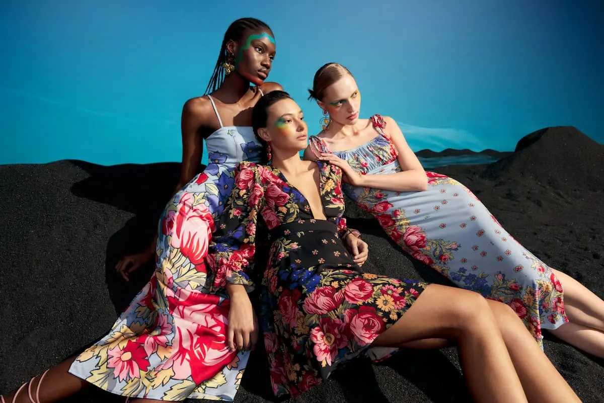 modelos con vestidos floreados y coloridos en un paisaje montañoso, al atardecer