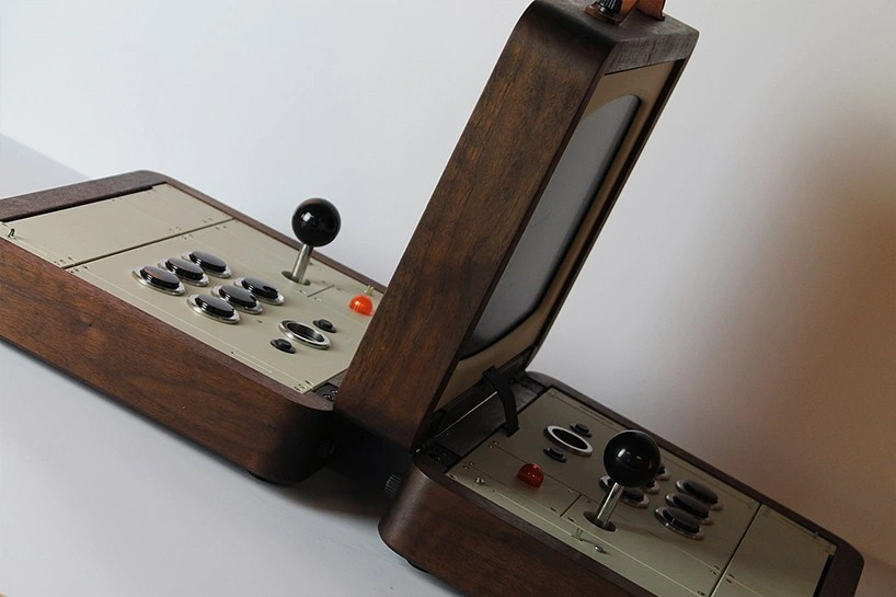 Consola arcade portátil de madera abierta, con dos palancas y botones a cada lado