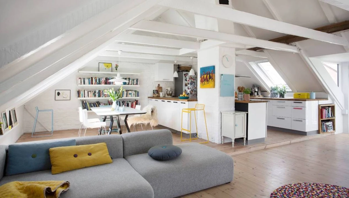Ático estilo nórdico con vigas blancas y sala monocromática