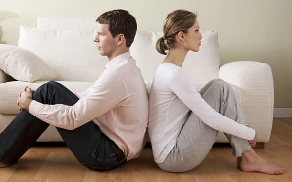 Padres e hijos sentados en sofá con ambiente tenso tras divorcio