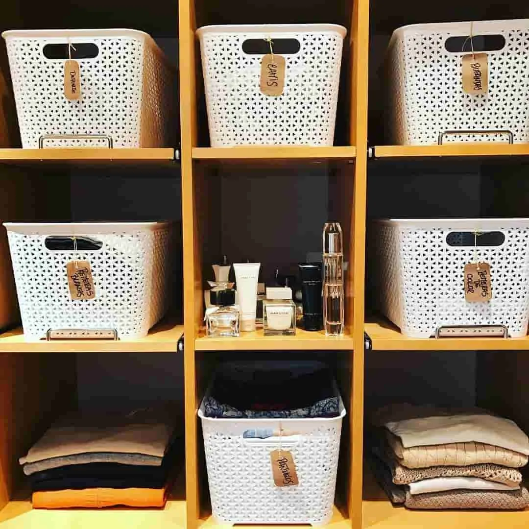 Closet moderno sin cajones con sistema de organización vertical usando contenedores y cestas etiquetadas