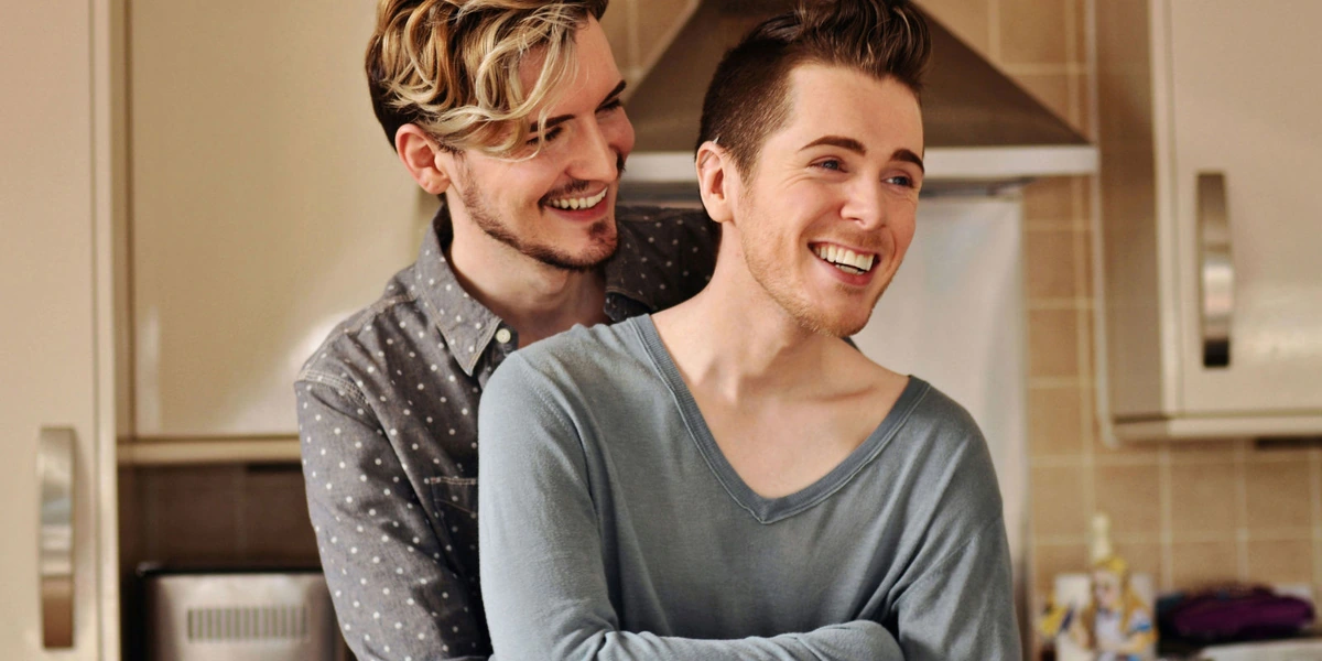 Pareja homosexual abrazados en su hogar muy contentos ambos
