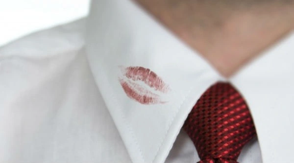 Los labiales y otros maquillajes pueden arruinar las prendas: debes actuar con rapidez. hombre con su camisa blanca con mancha de labial rojo en el cuello de la prenda