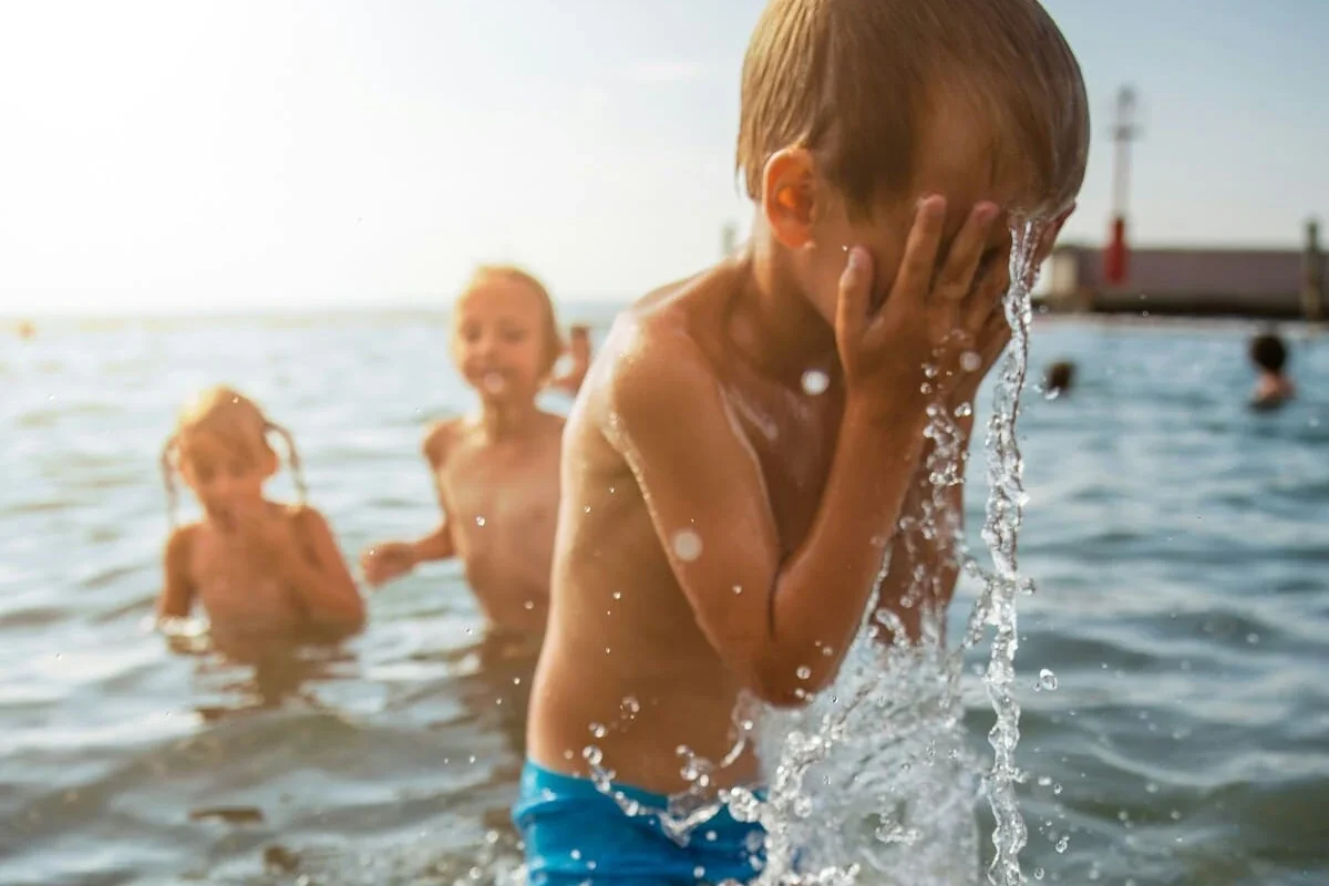 niños disfrutan de bañarse en el agua