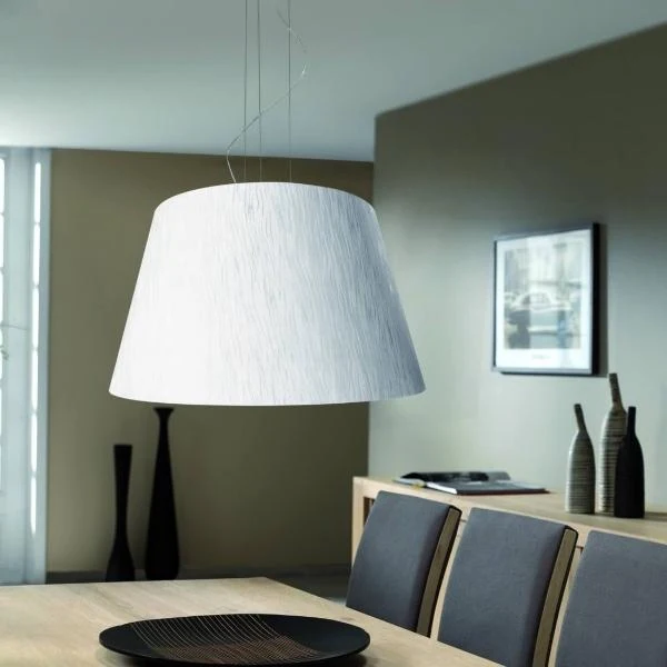 Lámpara colgante blanca minimalista sobre mesa de comedor de madera y sillas grises en espacio reducido