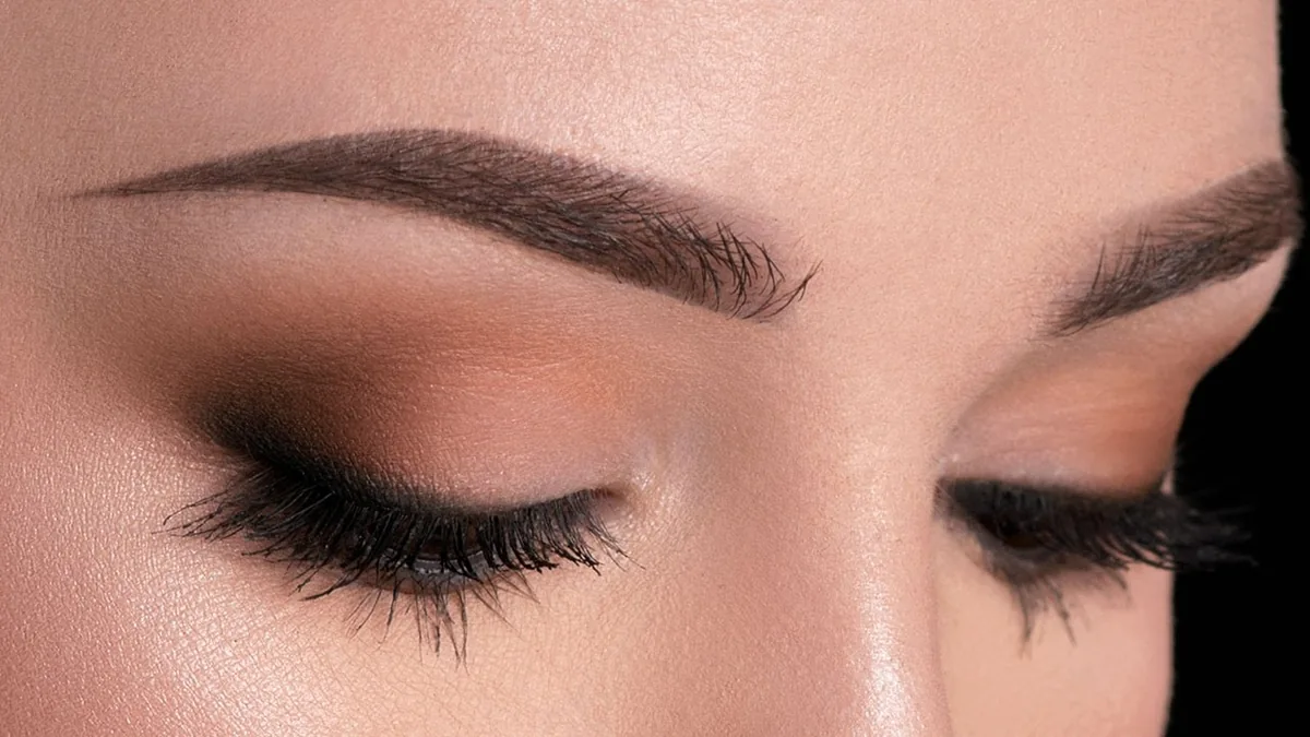 Ojos cerrados con sombra mate beige y pestañas definidas con máscara de día
