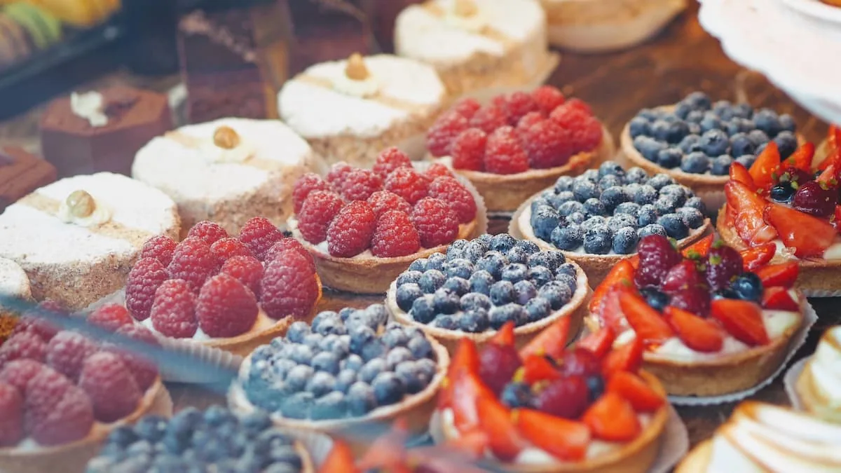 Ideas de Postres para tu Candy Bar Variedad de postres individuales como tartaletas de frutas frescas para una mesa de dulces, una idea elegante para cualquier fiesta.