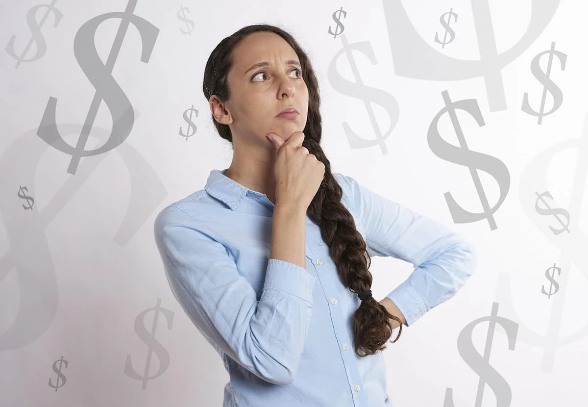 Mujer pensativa con fondo de signos de dólar, dudando sobre temas económicos.