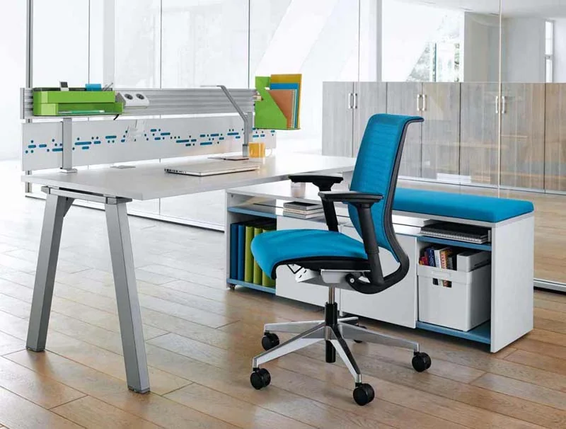Estación de trabajo moderna con silla ergonómica azul y soluciones de almacenamiento integradas para una oficina funcional y organizada.