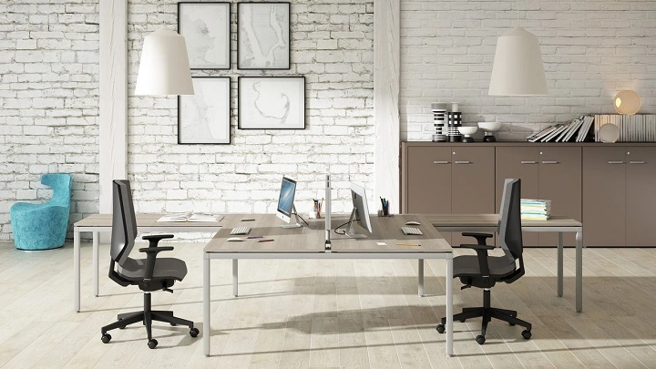 Espacio de oficina moderno con estaciones de trabajo colaborativas y sillas ergonómicas para fomentar la productividad del equipo.