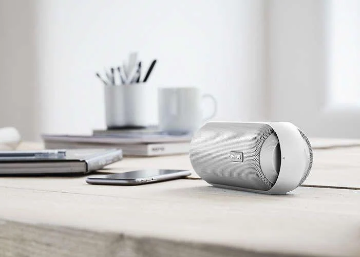 Altavoz inalámbrico moderno sobre escritorio, ideal para escuchar música en 2025.