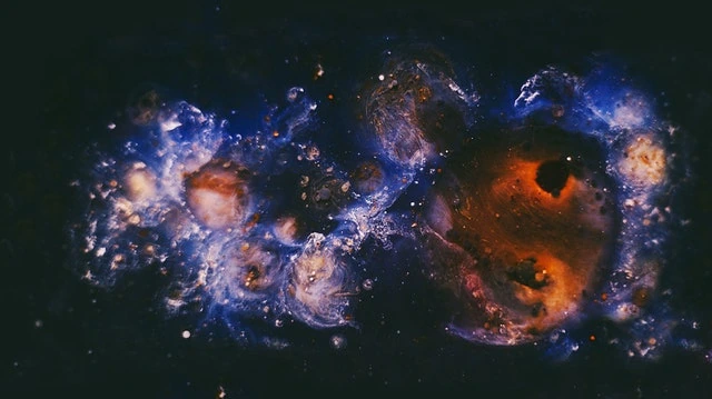 Nebulosa espacial de tonos azules y anaranjados sobre un fondo negro