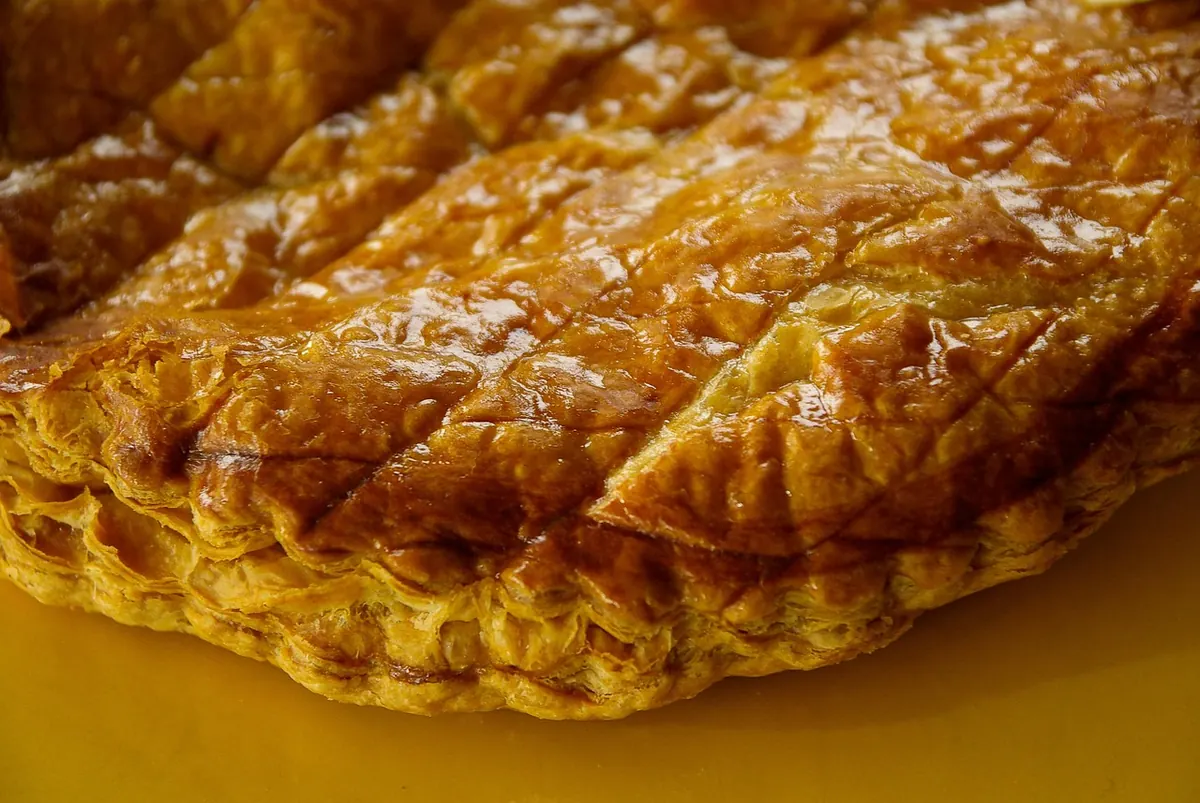 Primer plano de una crujiente rosca de Pascua de hojaldre, mostrando su superficie dorada, ideal para una versión rellena.