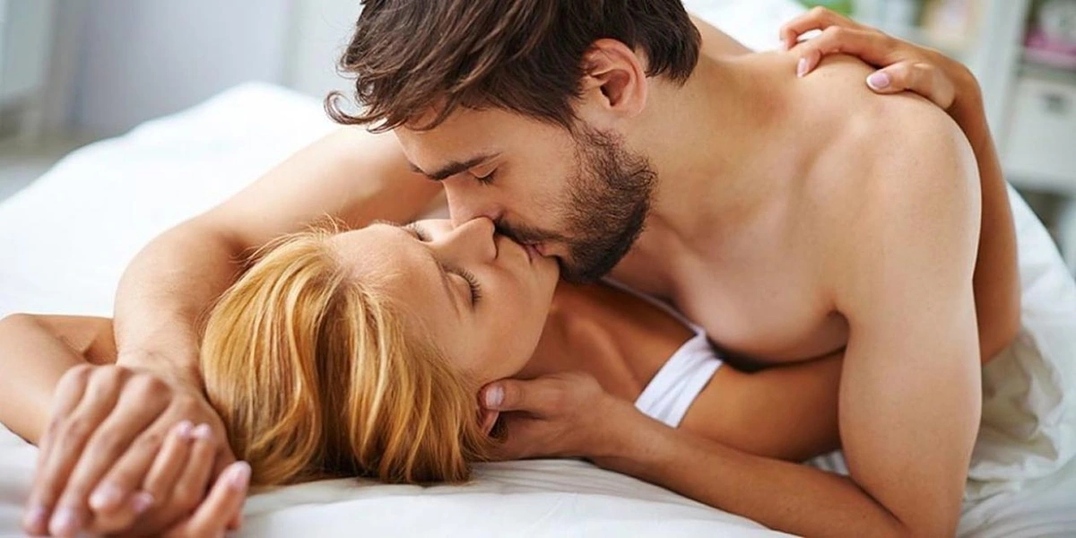 Hombre y mujer en la cama besándose en una foto apta para todas las edades