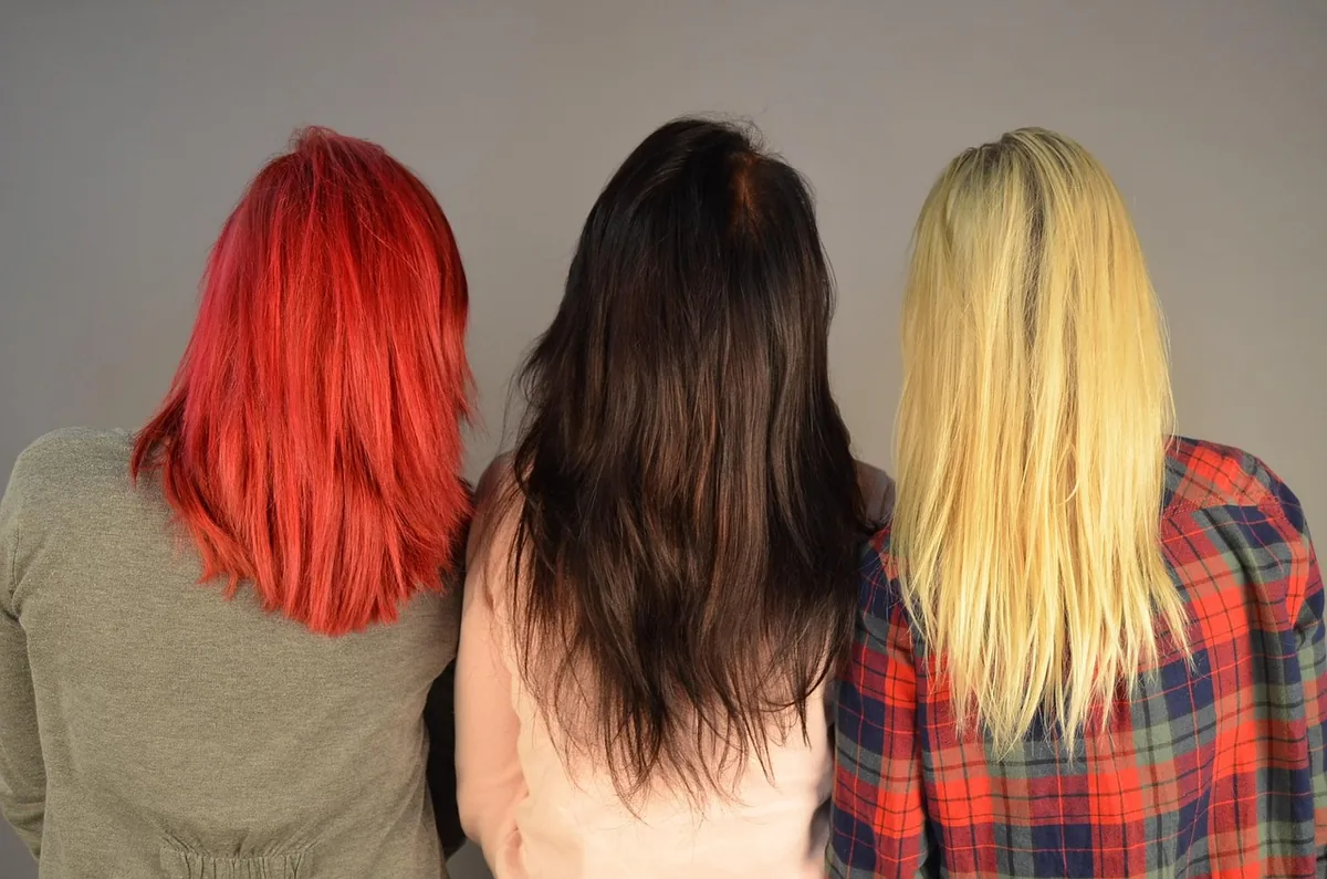 Cabello teñido de diferentes colores (rojo, castaño y rubio), demostrando la necesidad de un shampoo sin sulfatos para proteger cualquier tipo de tinte.
