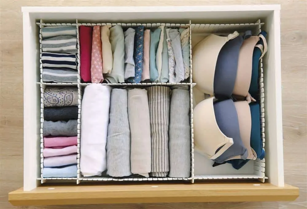 Cajón perfectamente organizado con ropa interior femenina doblada y separada por categorías en compartimientos