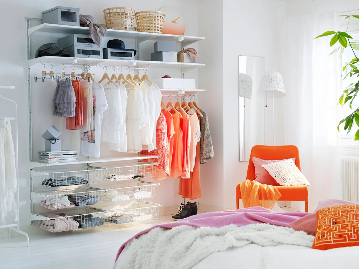 Vestidor moderno y organizado con ropa colgada y espacios definidos para diferentes tipos de prendas